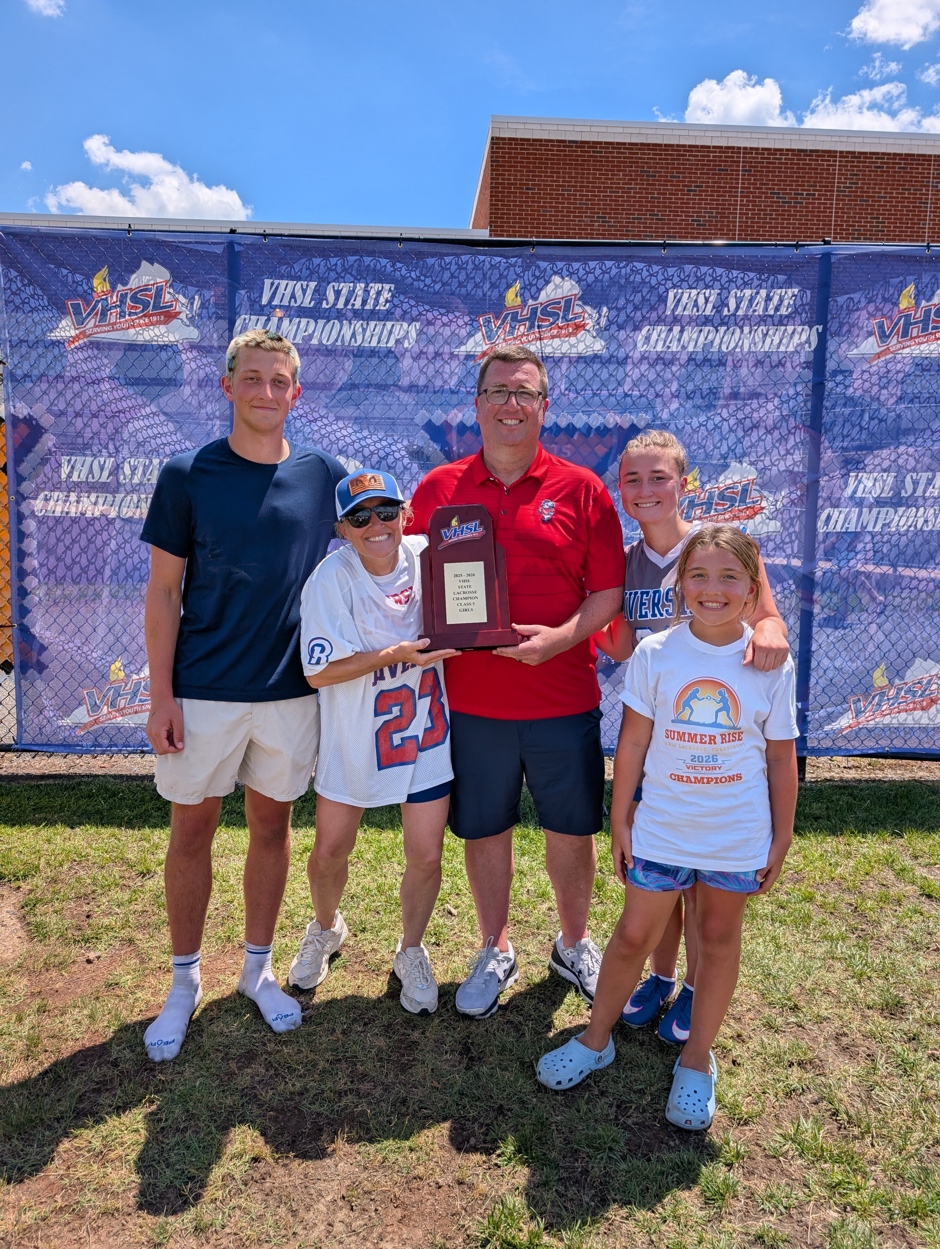 Joe, Jen, Andrew, and Avery celebrating with the VHSL State Lacrosse Championship trophy